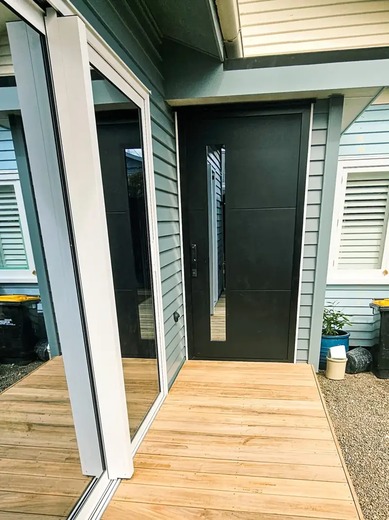 Exterior entrance with a dark front door, glazing and timber landing