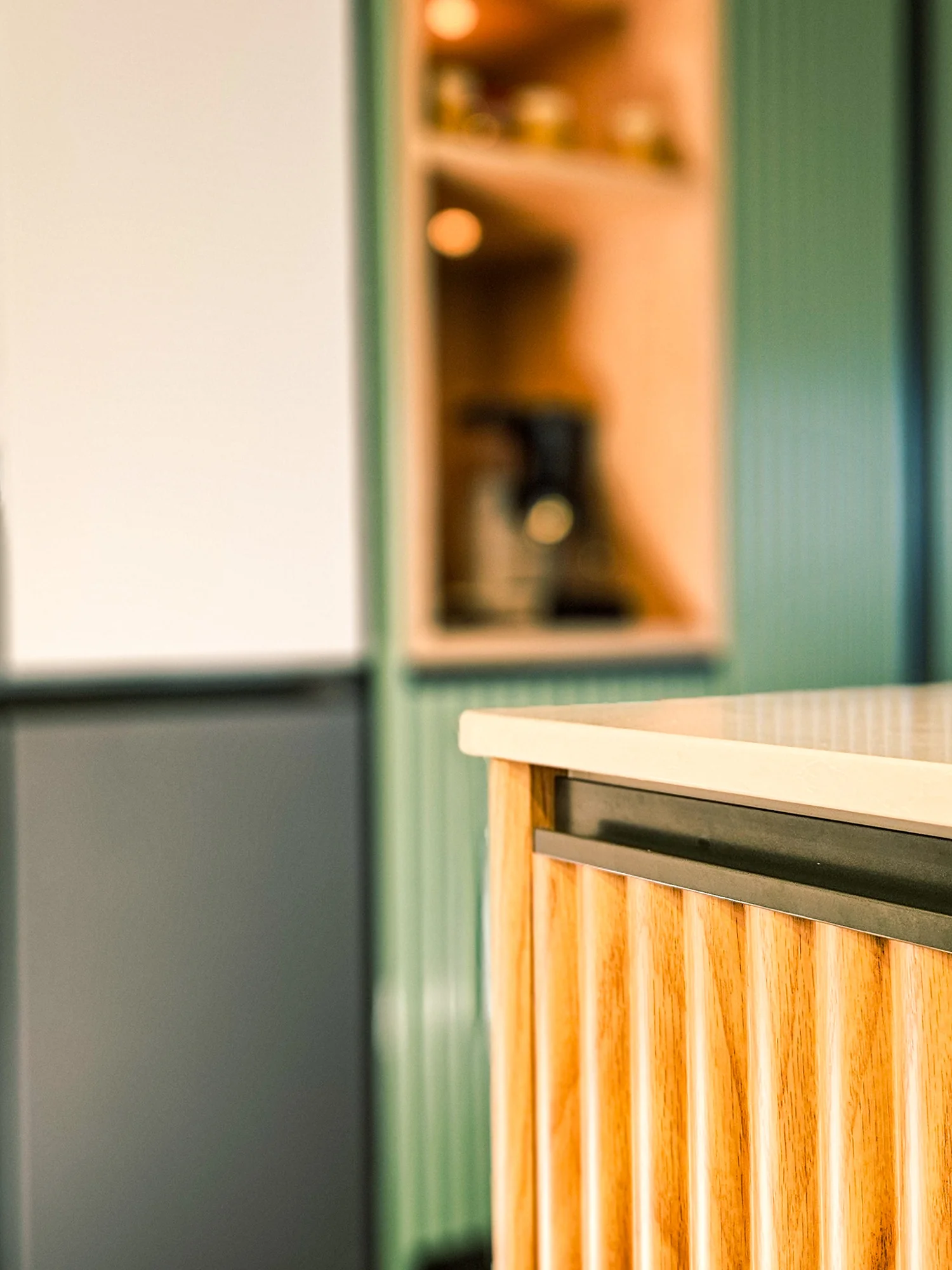 A close view of fluted timber and green kitchen cabinetry