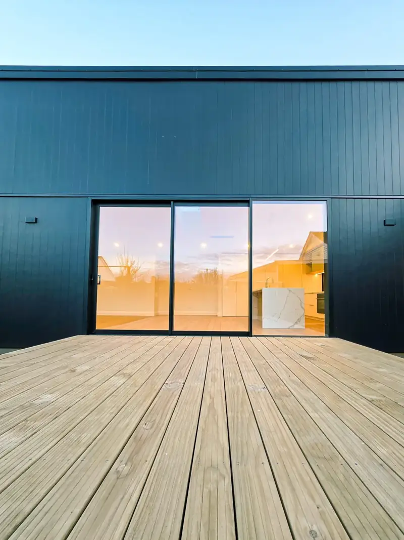 Charcoal-clad home opening onto a timber deck