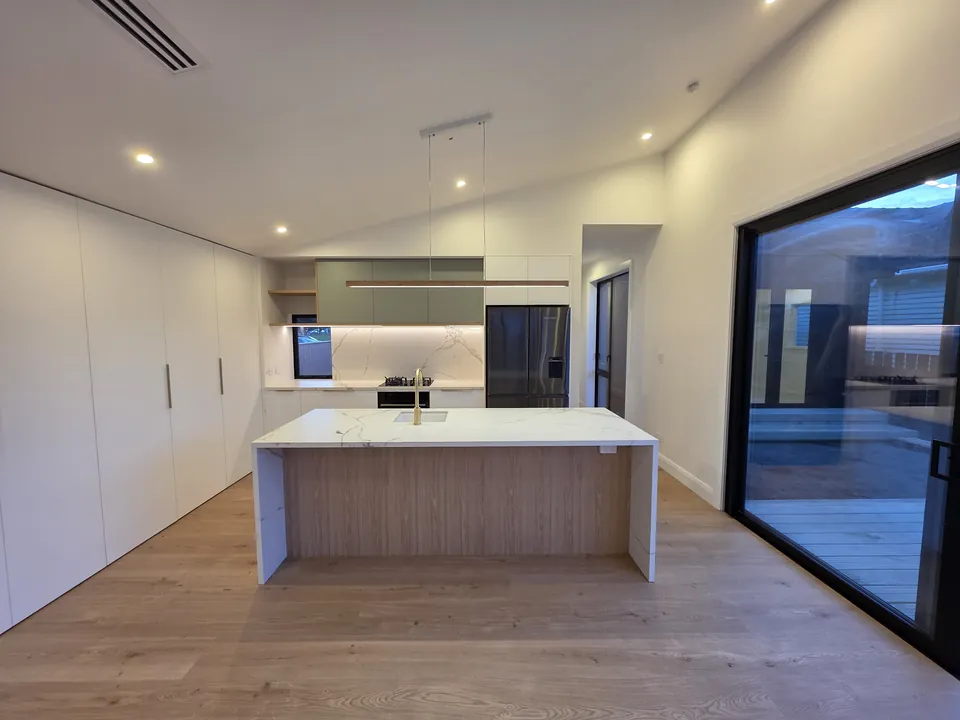 Bespoke kitchen and island beneath the vaulted ceiling