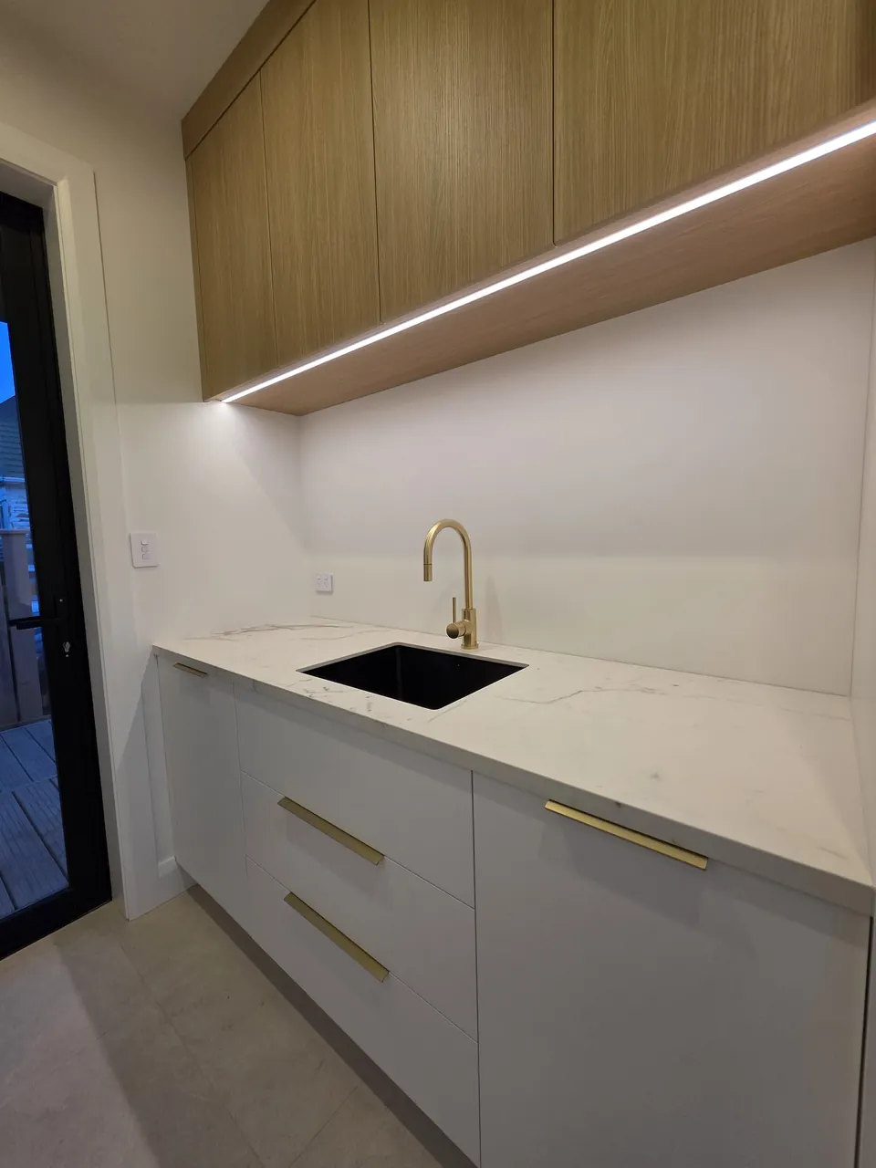 Laundry joinery with timber cabinets and stone worktop