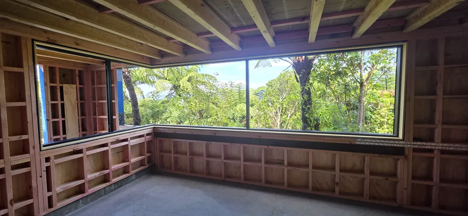 Wide window opening framing the green outlook during construction